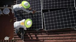 PALMETTO BAY, FL - JANUARY 23:  Roger Garbey (top) and Andres Hernandez, from the Goldin Solar company, install a solar panel system on the roof of a home a day after the Trump administration announced it will impose duties of as much as 30 percent on solar equipment made abroad on January 23, 2018 in Palmetto Bay, Florida. Daren Goldin the owner of the company said, 'the tariffs will be disruptive to the American solar industry and the jobs they create.'  (Photo by Joe Raedle/Getty Images)