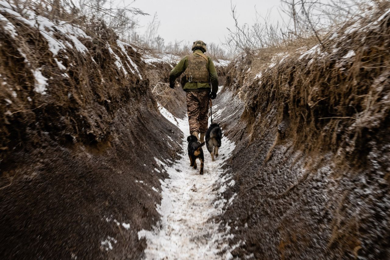 A soldier walks with dogs in a front-line trench. "I've been in the trenches many times before in the summer," Fadek said. "This is the first time it was in the winter. Visually, because the trenches and the landscape are covered in snow, it reminds me of World War I trenches. Cold misery."
