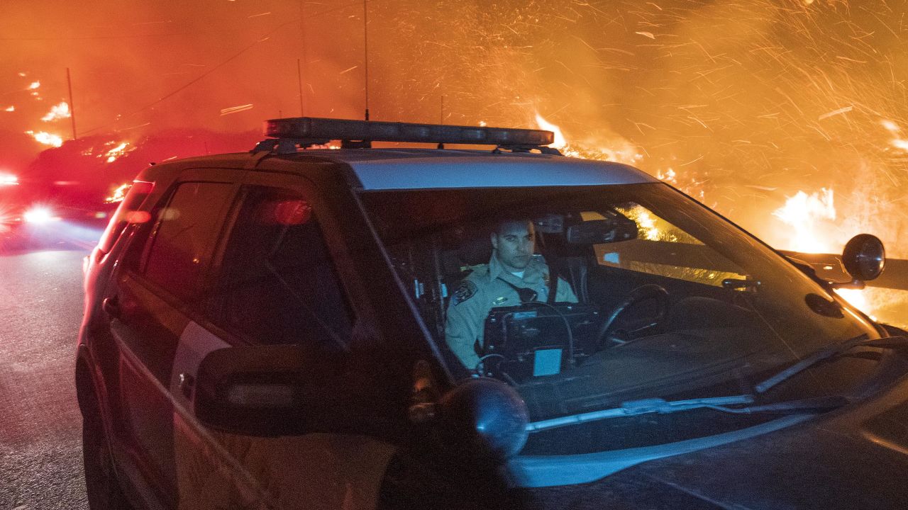 A California Highway Patrol officer drives south on Highway 1 as the Colorado Fire burns near Big Sur, California.