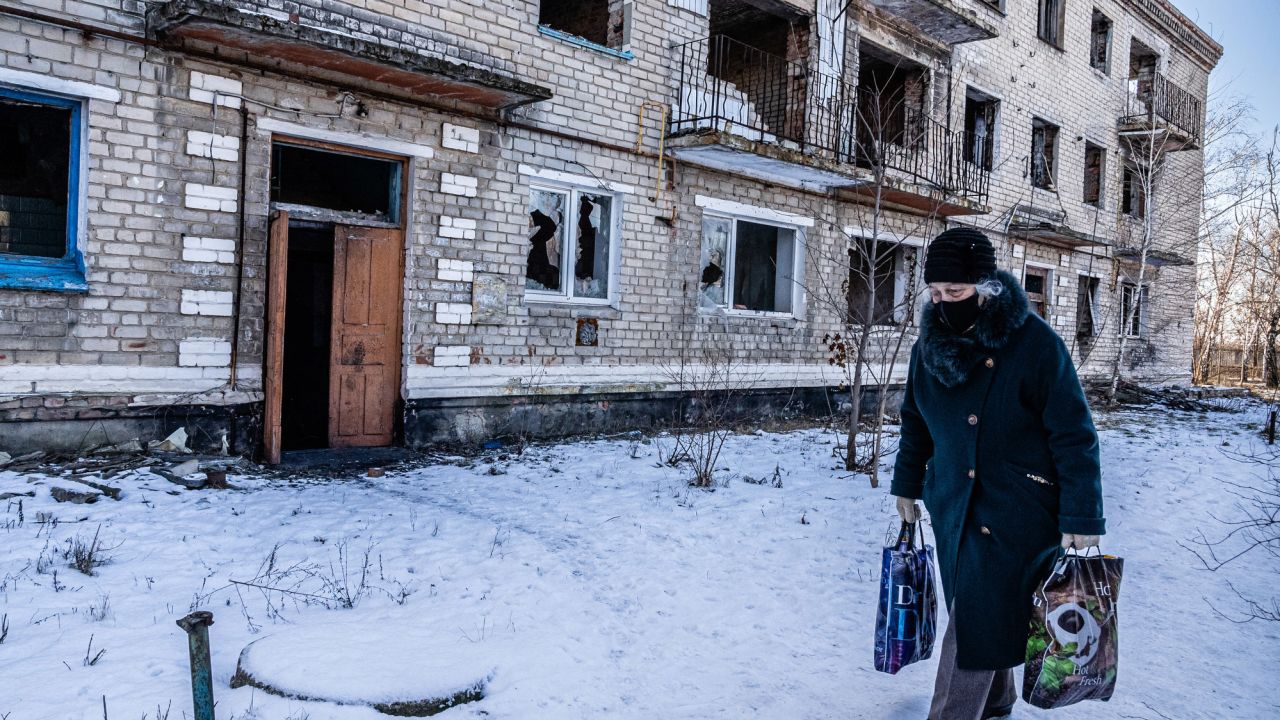 Local residents Marinka, Ukraine, walk past an apartment building destroyed during fighting in 2015 between the Ukrainian army and Russian-backed separatists. Fighting is still ongoing.