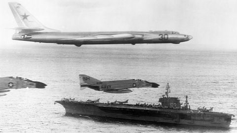 A Russian-made Tupolev TU-16 Badger-A surveillance bomber flies with US Navy escort fighters over the attack carrier USS Kitty Hawk during Cold War activities over the North Pacific Ocean in January of 1963. 