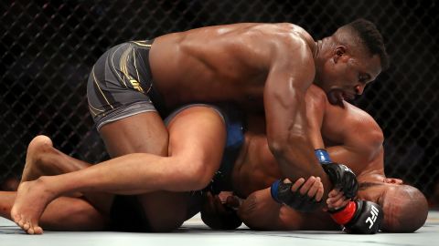 Ngannou grapples on the ground with Gane.