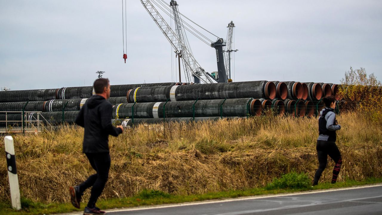 Runners pass pipes for the Nord Stream 2 gas pipeline at Mukran Port in Sassnitz, Germany.