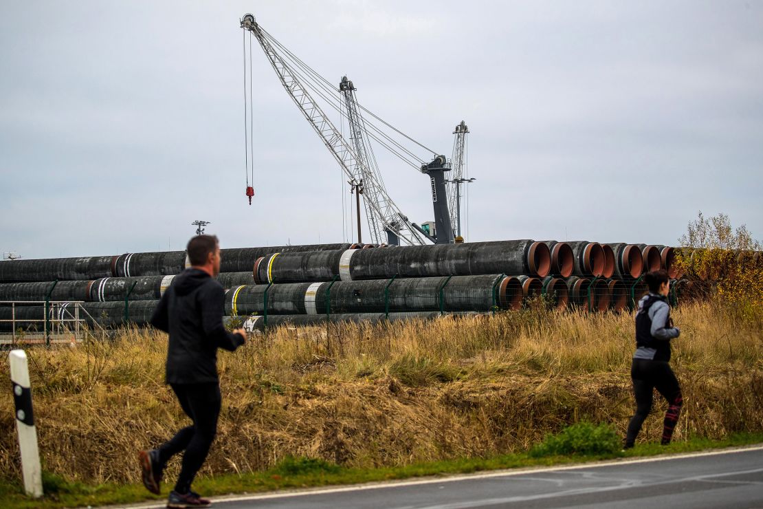 Runners pass pipes for the Nord Stream 2 gas pipeline at Mukran Port in Sassnitz, Germany.