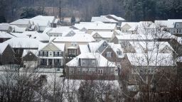 Snow and rain fall on rooftops of houses in the Bellevue community Sunday, Jan. 16, 2022 in Nashville, Tennessee.