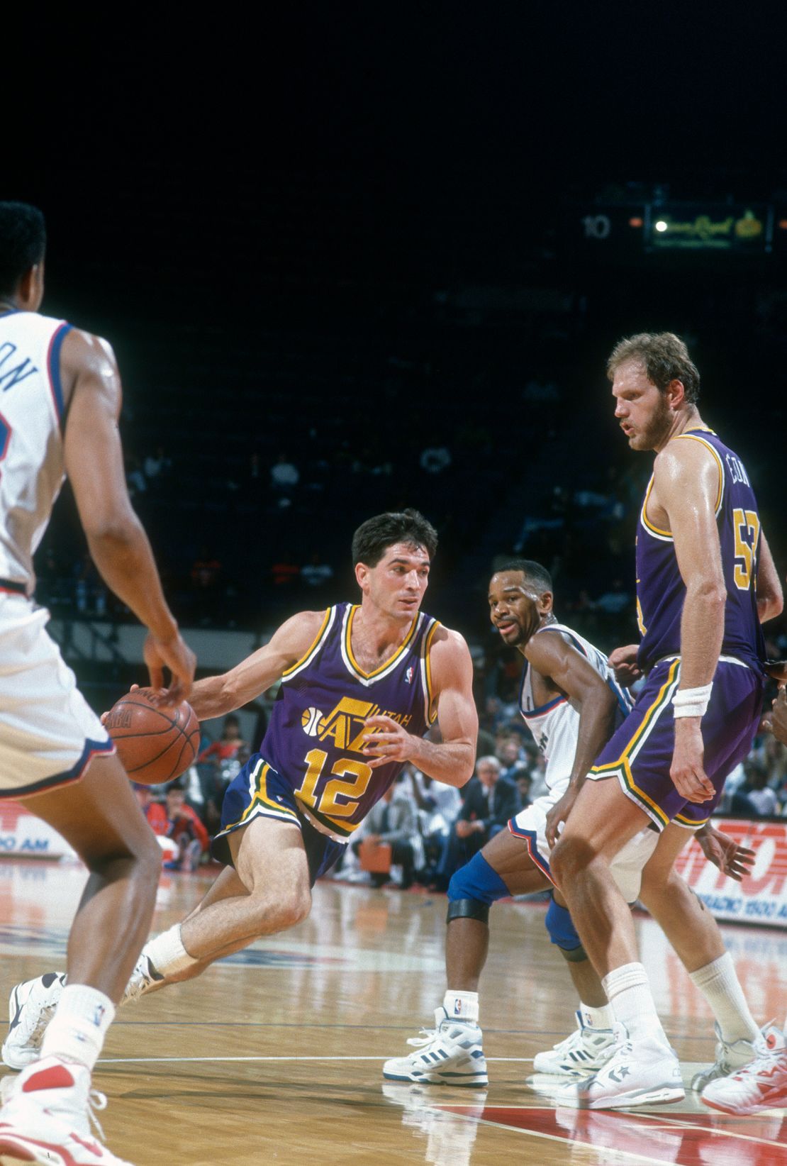 John Stockton of the Utah Jazz drives towards the basket past Michael Adams (#10) of the Washington Bullets during a 1991 NBA basketball game.