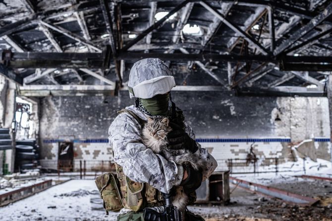 A Ukrainian soldier holds a cat in Avdiivka.