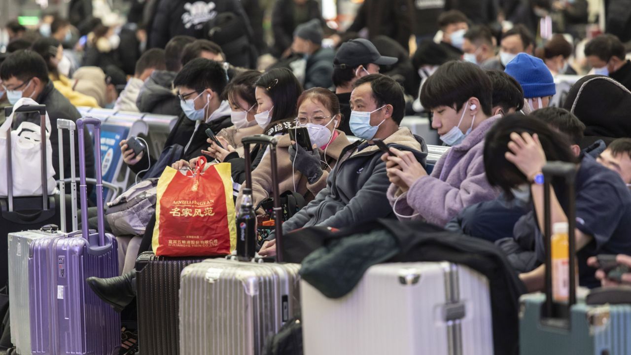 Travelers wearing masks wait in the main hall of Shanghai's Hongqiao Railway Station ahead of Lunar New Year, on January 23, 2022.