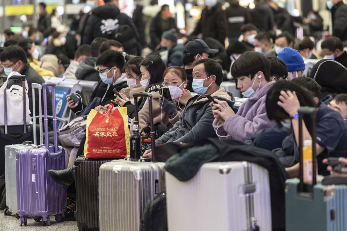 Travelers wearing masks wait in the main hall of Shanghai's Hongqiao Railway Station ahead of Lunar New Year, on January 23, 2022.