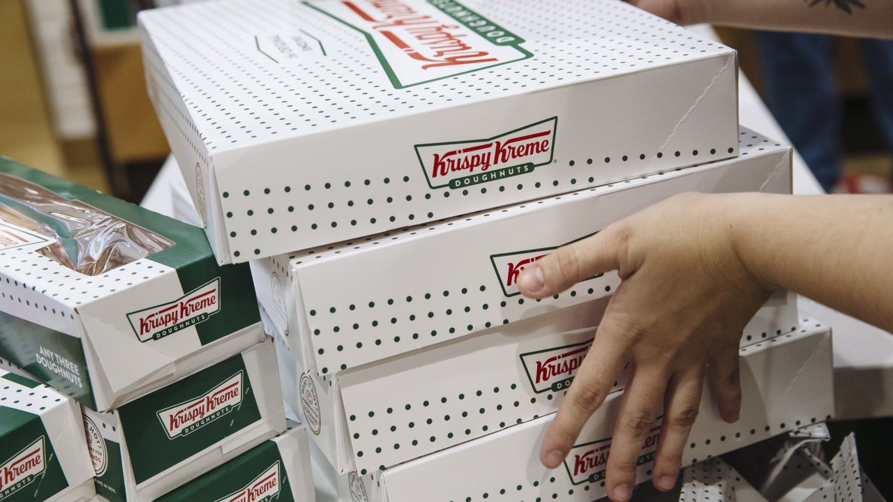 An employee carries boxes of doughnuts inside a Krispy Kreme store in the Times Square.