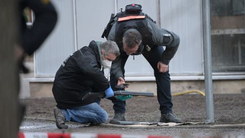 Police officers examine a weapon on the campus of Heidelberg University after the shooting.