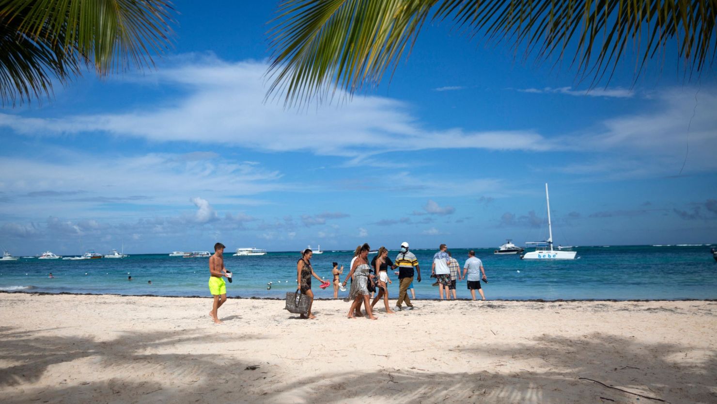 Tourists enjoy a beach in Punta Cana in the Dominican Republic, on January 7, 2022. - Almost 5 million tourists visited Dominican Republic in 2021, compared to the 6.4 million reported in 2019 before the pandemic started. With a significant growth in tourism and at the same time of infections by Covid-19, hotels in the Dominican Republic allocate areas to isolate tourists sick with the virus. (Photo by Erika SANTELICES / AFP) (Photo by ERIKA SANTELICES/afp/AFP via Getty Images)