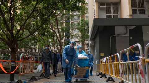 보건 당국자들이 1월 23일 홍콩의 폐쇄된 주거용 건물 밖에서 보급품 카트를 밀고 있다.