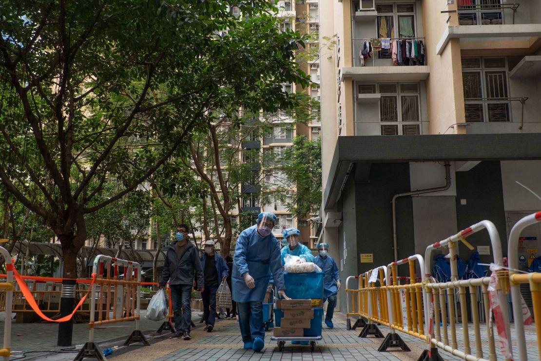 Health officials push a trolley of supplies outside a locked-down residential building in Hong Kong on January 23. 