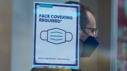 A sign reminds customers that masks are required in their store in New York, Monday, Dec. 13, 2021. A mask mandate for shops and other indoor spaces in New York state took effect Monday as officials confront a surge in COVID-19 cases and hospitalizations. (AP Photo/Seth Wenig)