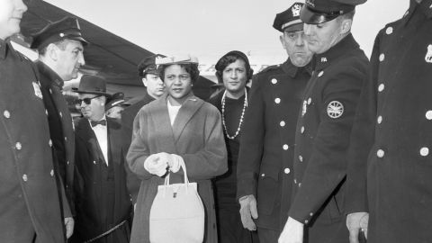Autherine Lucy and Constance Baker Motley walk through a police line after Lucy's expulsion from the University of Alabama, where she was the school's first Black student, March 1, 1956.