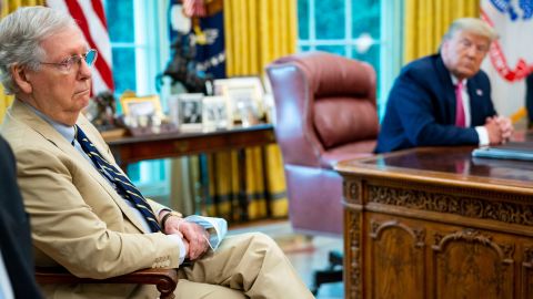 McConnell listens as then-President Donald Trump talks to reporters while hosting Republican congressional leaders and members of Trump's cabinet in the Oval Office at the White House in July 2020 in Washington, DC.