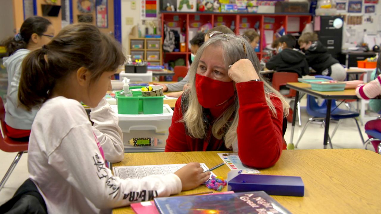 Jan Stone helps a student on her first day of substitute teaching.