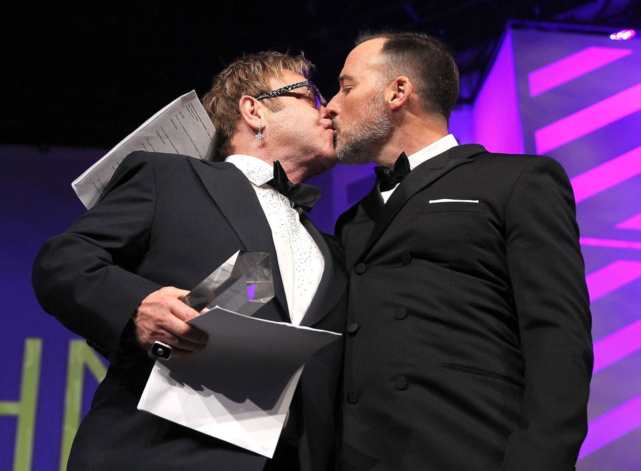 John and Furnish kiss at the Human Rights Campaign's National Dinner in 2014. They married in December of that year.