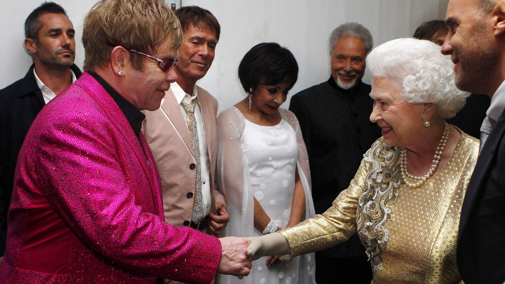 Britain's Queen Elizabeth II shakes hands with John at her Diamond Jubilee Concert in 2012. In 1998, the Queen knighted John for his music and charity work.