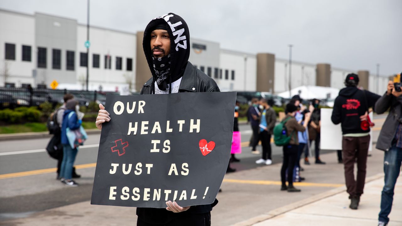 Chris Smalls, a fired Amazon fulfillment center employee, center, holds a sign during a protest outside an Amazon.com facility in the Staten Island borough of New York, U.S., on Friday, May 1, 2020. Workers at Amazon, Whole Foods, Instacart, Walmart, FedEx, Target, and Shipt said they would walk off the job to protest their employers' failure to provide basic protections for employees who are risking their lives at work. Photographer: Michael Nagle/Bloomberg via Getty Images