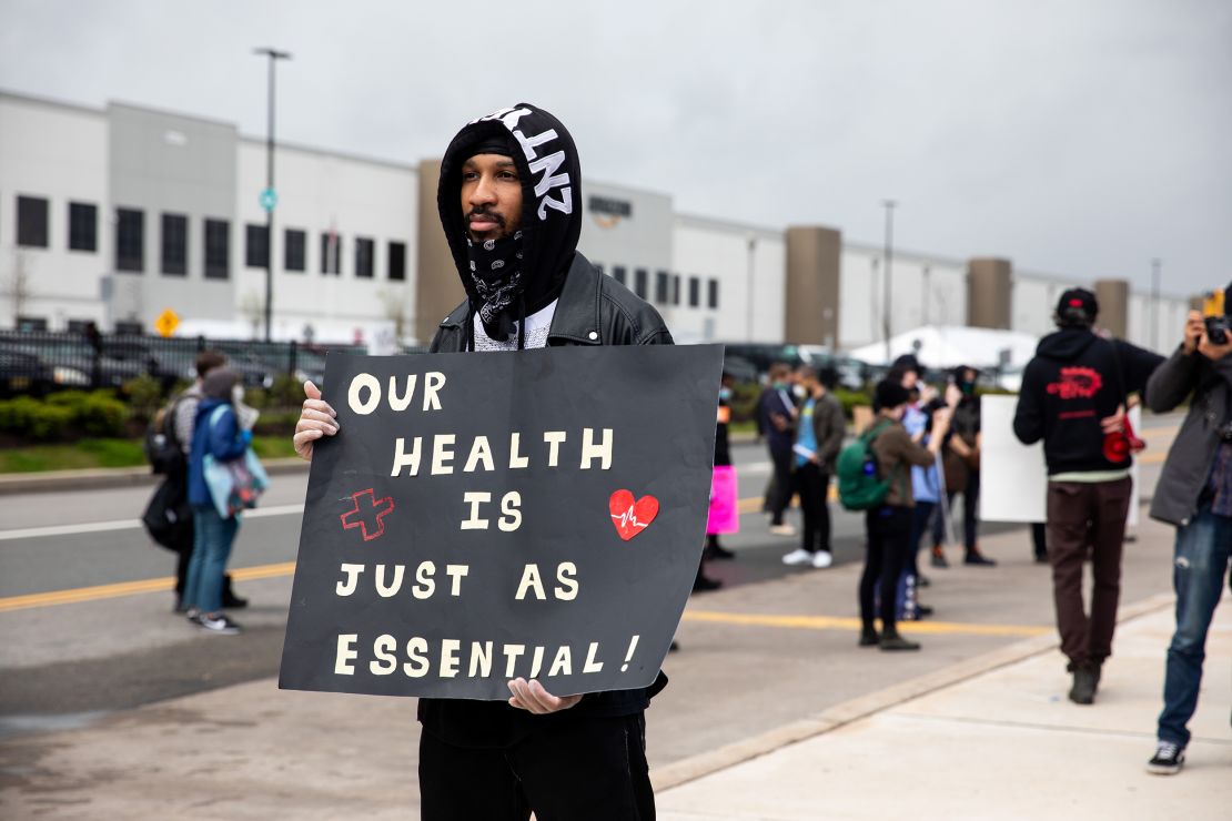 Chris Smalls, a fired Amazon fulfillment center employee, center, holds a sign during a protest outside an Amazon.com facility in the Staten Island borough of New York, U.S., on Friday, May 1, 2020. 