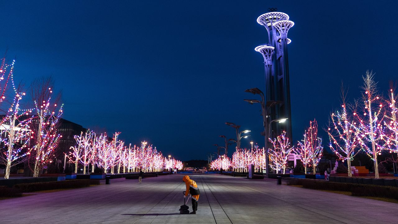 A worker cleaning a section of the Olympic Green in front of the Beijing Olympic Tower on Wednesday.