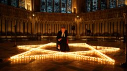 YORK, ENGLAND - JANUARY 26:  The Reverend Canon Michael Smith, Acting Dean of York lights some of the 600 candles shaped as a Star of David on the floor of the Chapter House of York Minster as part of a commemoration for Holocaust Memorial Day on January 26, 2022 in York, England. This year marks the 77th anniversary since the liberation of the Auschwitz-Birkenau concentration camp in 1945, which was the largest Nazi death camp. The Holocaust genocide took place during World War II during which Adolf Hitler's Nazi Germany and its collaborators systematically murdered some six million European Jews.  (Photo by Ian Forsyth/Getty Images)