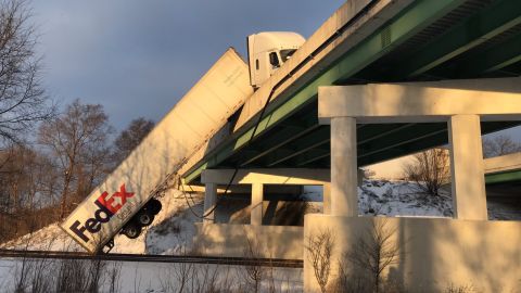 A FedEx truck hangs over a bridge during icy conditions Wednesday in Indiana.