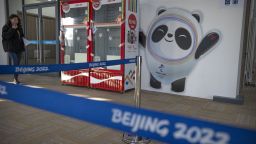 A staff member walks past a mural of the Olympic mascot Bing Dwen Dwen and Coca Cola-branded refrigerators at the Winter Olympic Village in Beijing, Friday, Dec. 24, 2021. Organizers on Friday gave the media a look at parts of the athletes' Olympic Village for the 2022 Winter Olympics and Paralympics, which will be held beginning in February. (AP Photo/Mark Schiefelbein)