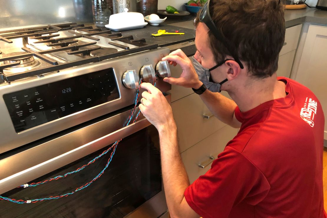 Researcher Eric Lebel attaches sensors to a stove to measure how often it is used. 