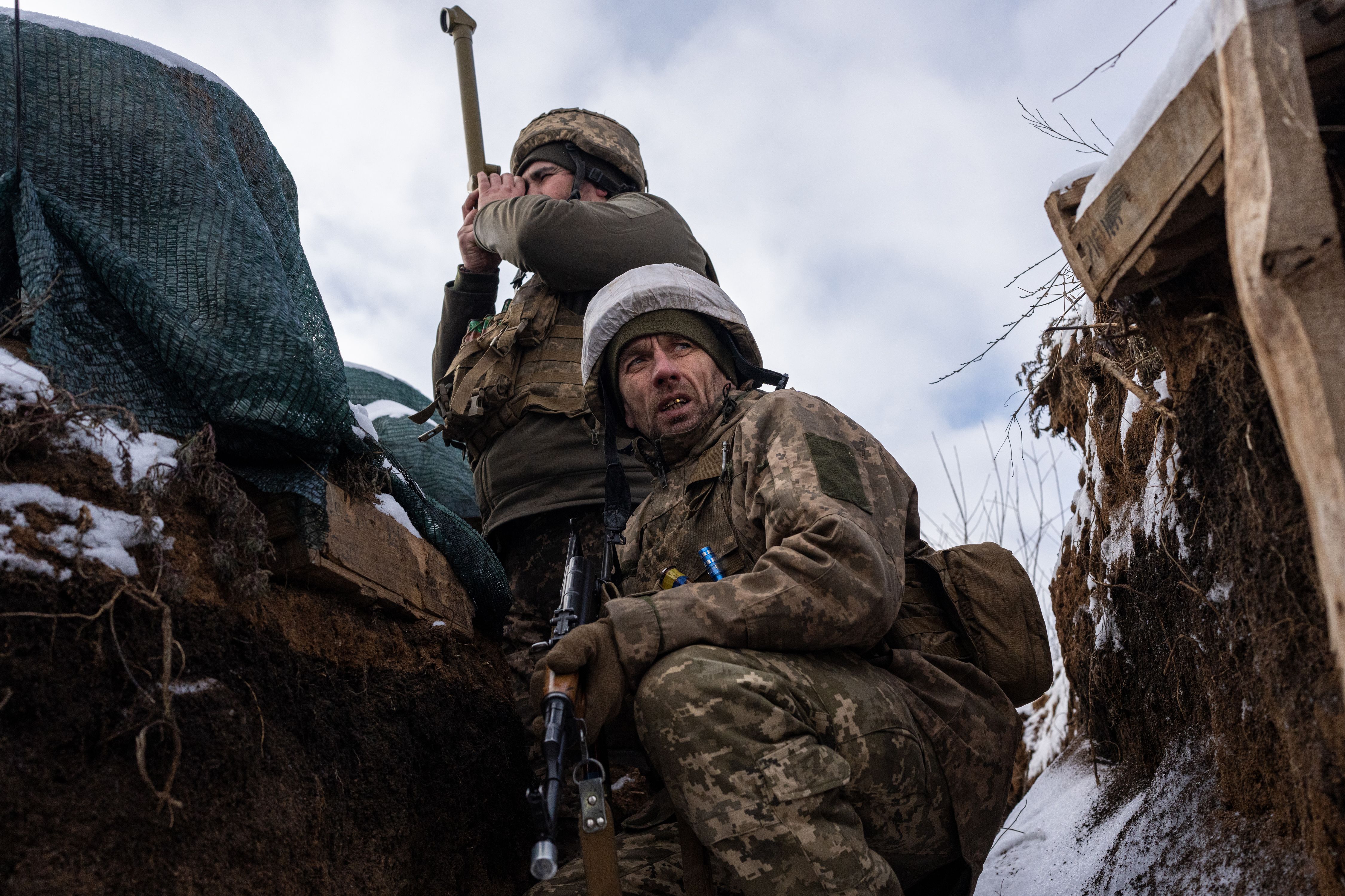 A shell-shocked Ukrainian soldier in a trench is getting taken