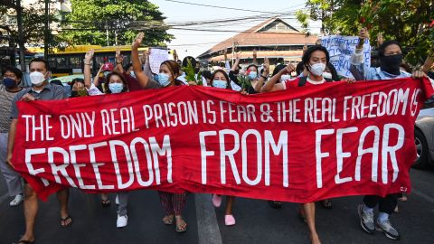 Protesters hold a banner as they take part in a demonstration against the military coup in Yangon on December 5, 2021.