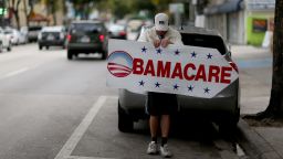A person holds a sign directing people to an insurance company where they can sign up for the Affordable Care Act, also known as Obamacare, before the February 15th deadline on February 5, 2015 in Miami, Florida. 