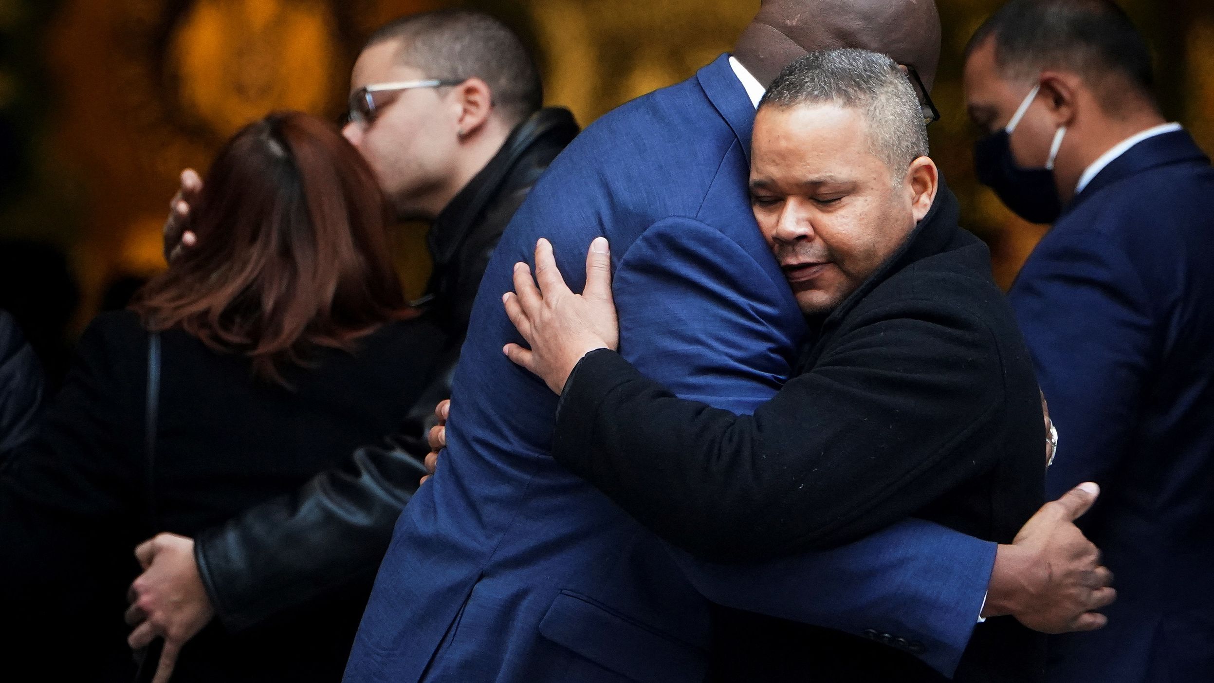 Friends and family hug at Rivera's wake on January 27.