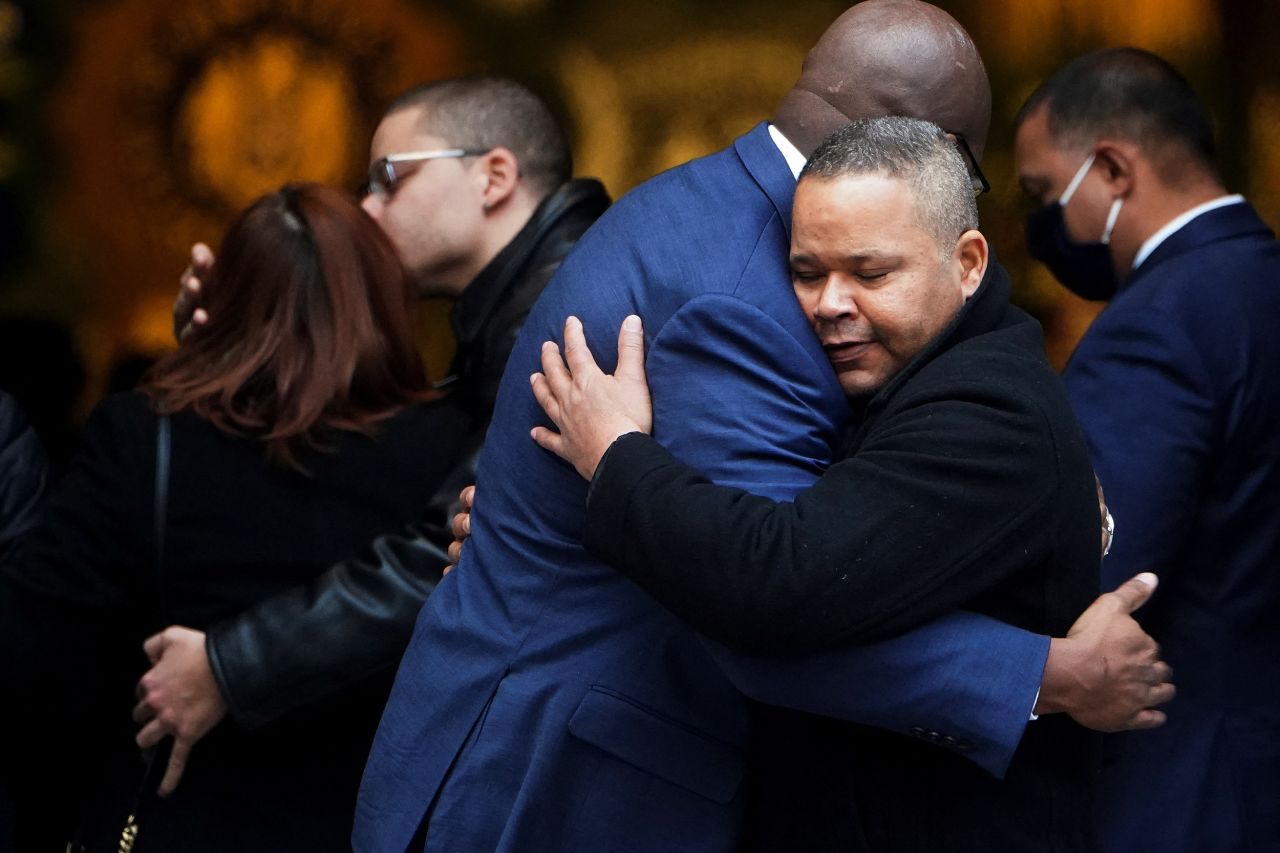 Friends and family hug at Rivera's wake on January 27.