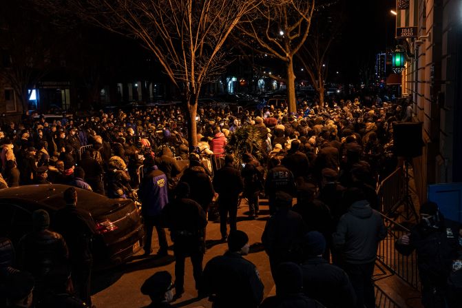 Hundreds of people attend a vigil for Mora and Rivera in front of the 32nd Precinct station house in Harlem on January 26.