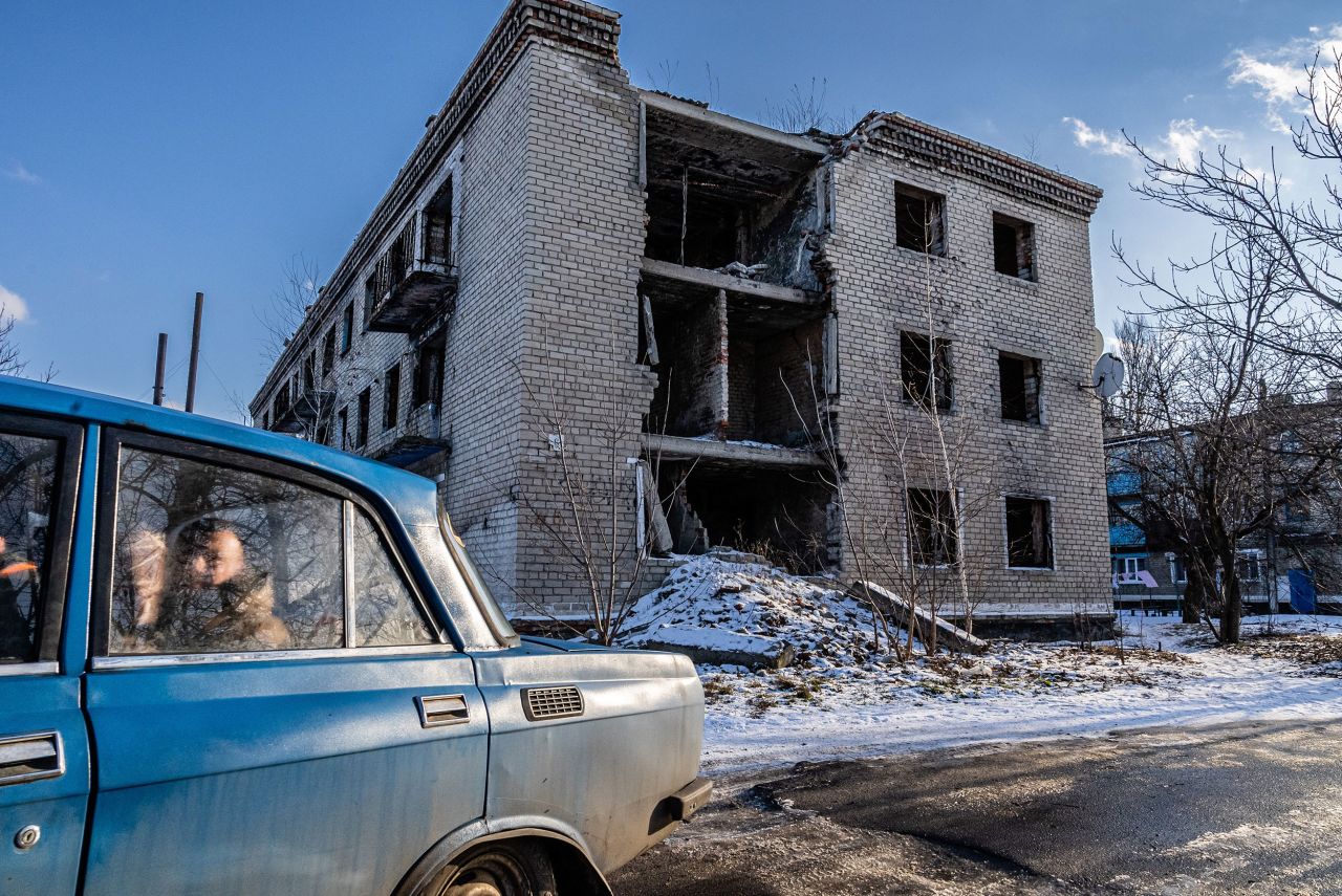 Local residents drive past an apartment building in the Ukrainian city of Marinka on Saturday, January 22. The building was badly damaged during fighting in 2015 between the Ukrainian army and Russian-backed separatists. "Although this small city is less than 15 miles from the separatist front line, residents try to continue their lives as normal as possible," said Timothy Fadek, who has been <a href="http://www.cnn.com/2022/01/21/europe/gallery/ukraine-russia-fadek/index.html" target="_blank">taking photos in the region</a> over the past week.