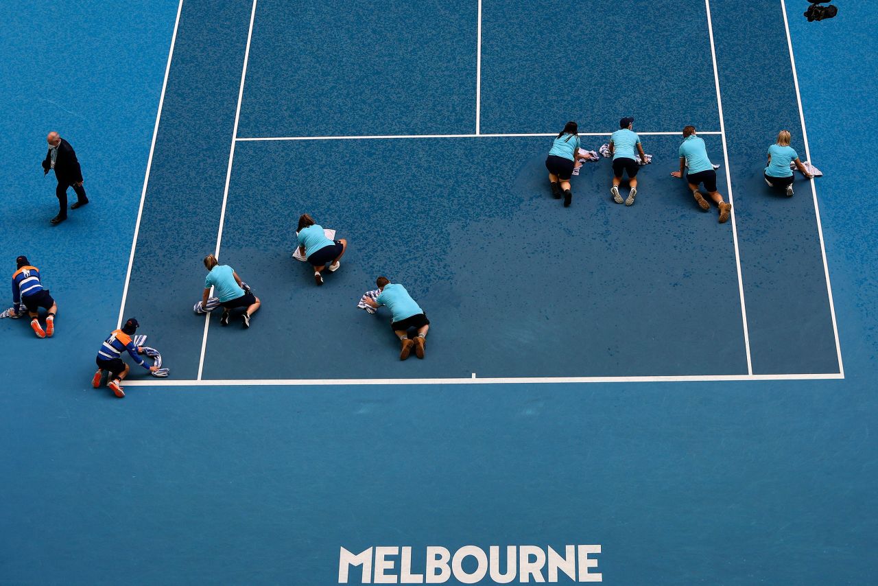Ball kids dry the court after rain at the Australian Open on Wednesday, January 26.