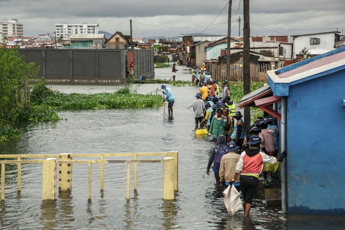 People walking through flood water in Antananarivo, Madagascar, on Monday. 