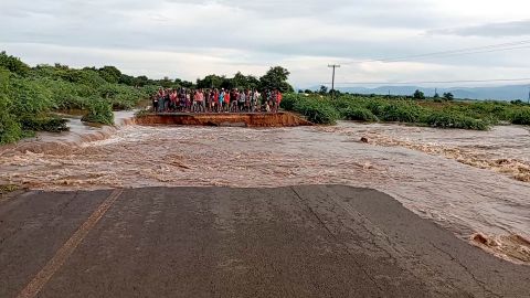 People stand on the other side of a road destroyed by tropical storm Ana, along M1 Chikwawa road, Malawi. 