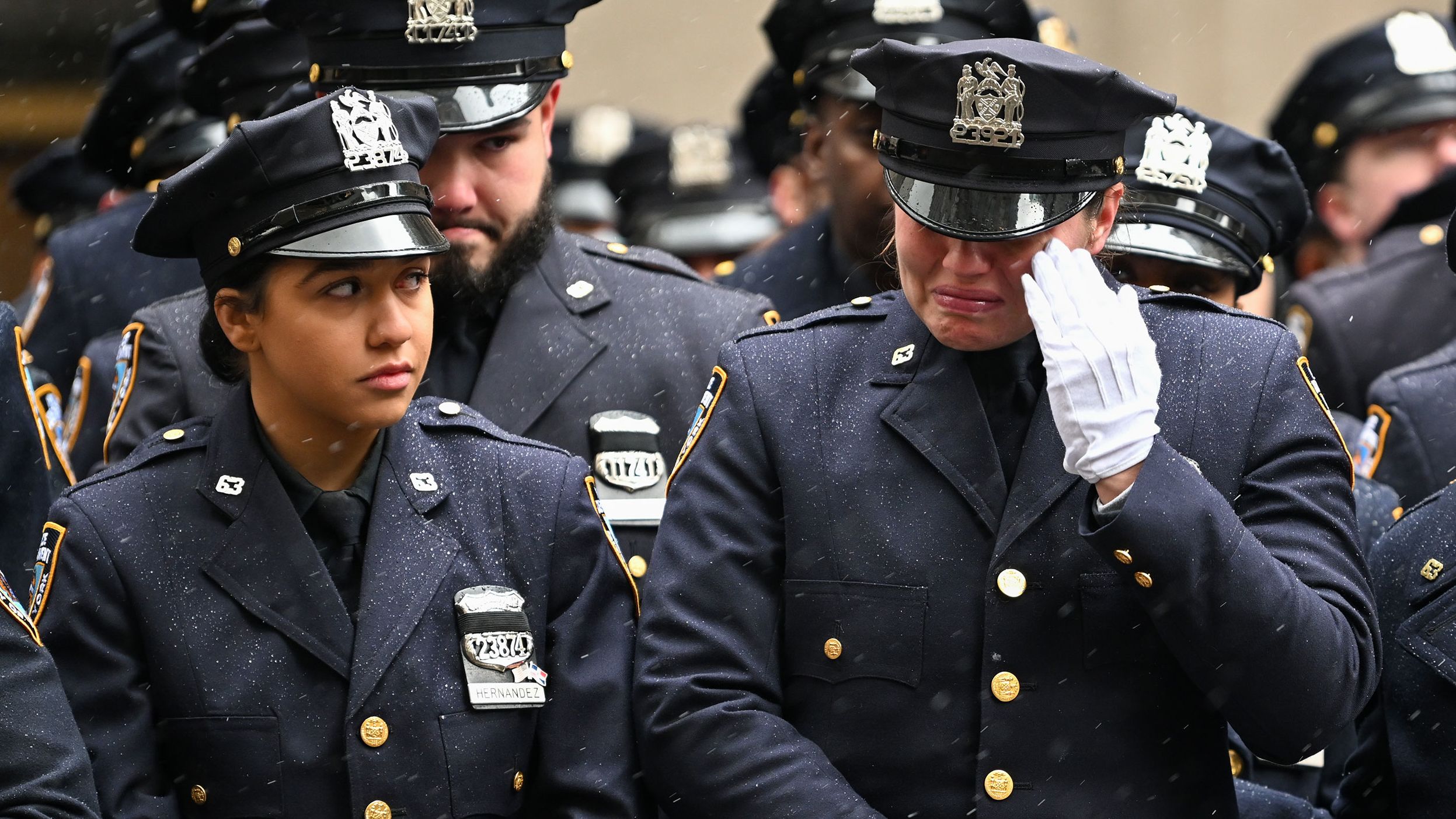 A police officer wipes away a tear during Rivera's funeral.