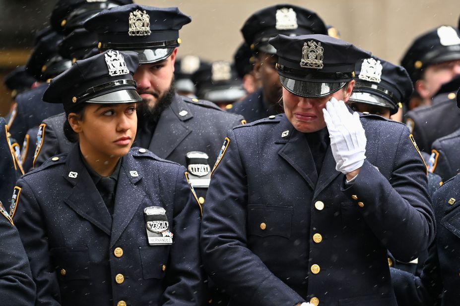 A police officer wipes away a tear during Rivera's funeral.