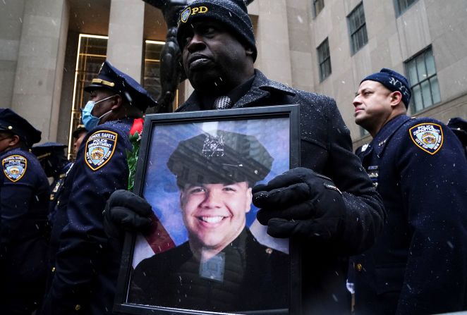 A man holds a picture of Rivera during his funeral service.