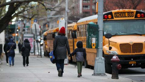 A parent walks with their child outside a New York City elementary school on December 7, 2020. 