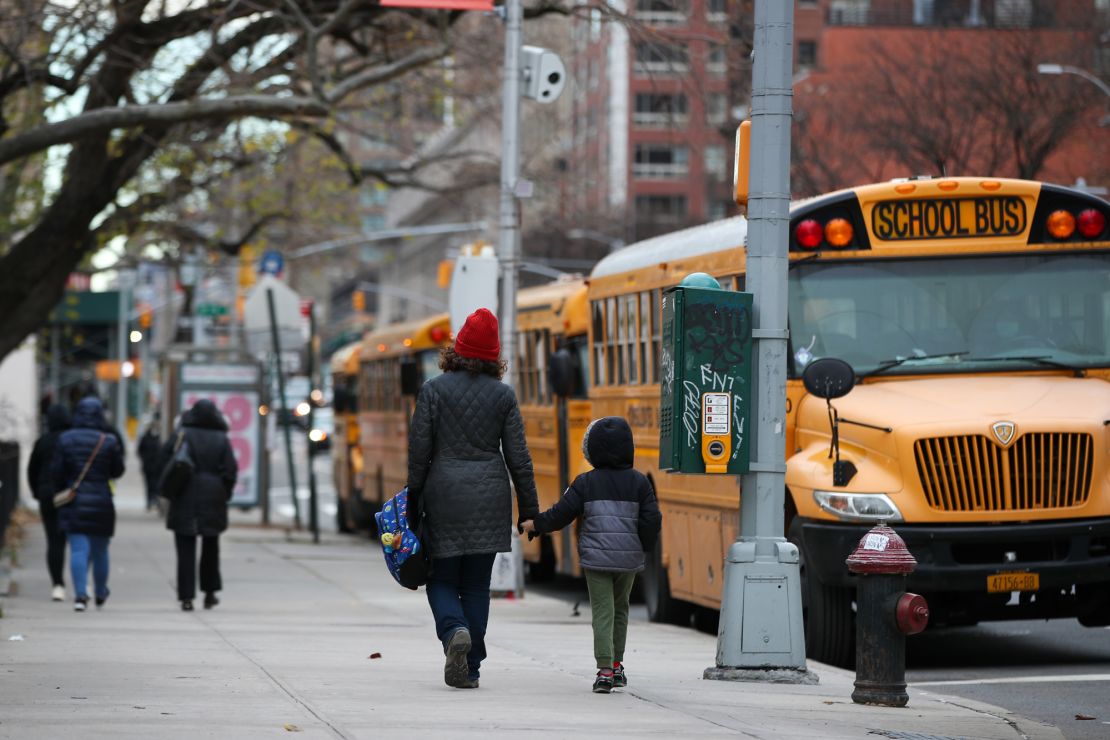 A parent walks with their child outside a New York City elementary school on December 7, 2020. 