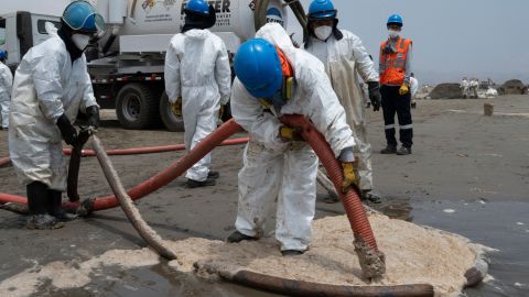 Cleaning crews work to remove oil from a beach in the Peruvian summer resort town of Ancón, in northern Lima, on January 20.