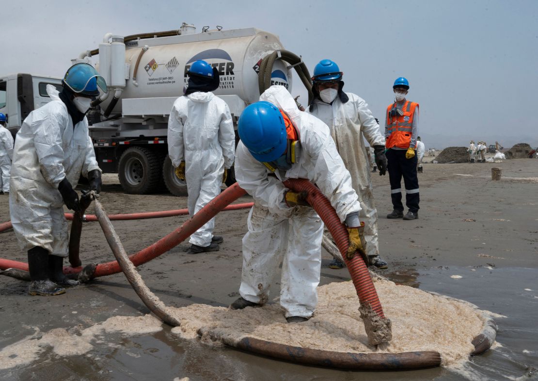 Cleaning crews work to remove oil from a beach in the Peruvian summer resort town of Ancón, in northern Lima, on January 20.