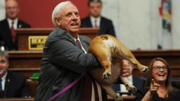 West Virginia Gov. Jim Justice holds up his dog Babydog's rear end as a message to people who've doubted the state as he comes to the end of his State of the State speech in the House chambers, Thursday, January 27, 2022, in Charleston, West Virginia. 
