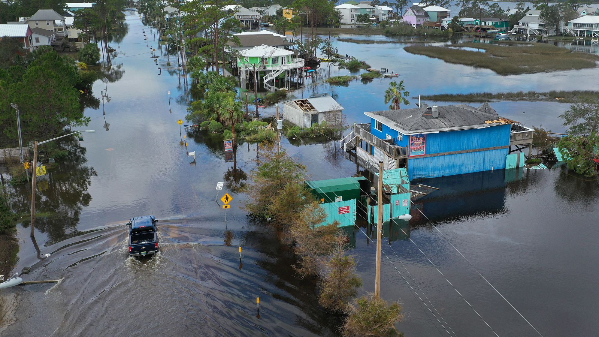 A vehicle drives through a flooded street after Hurricane Sally struck Gulf Shores, Alabama, in 2020.